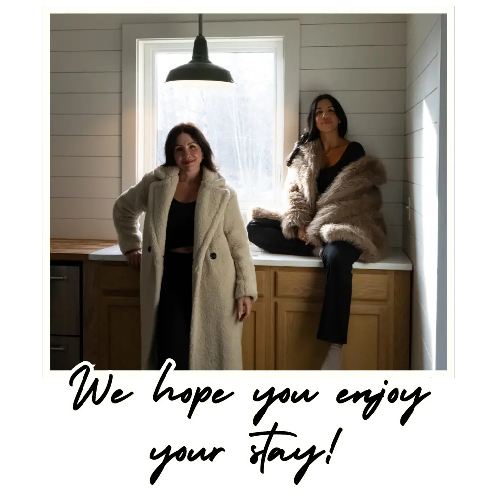 Two women inside Borealis Bison Barns kitchen with text reading “We hope you enjoy your stay”