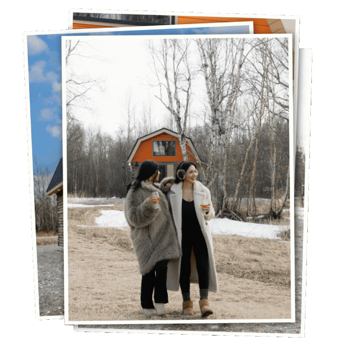 Two women walking near Borealis Bison Barns in Palmer Alaska holding drinks beside cabin rental