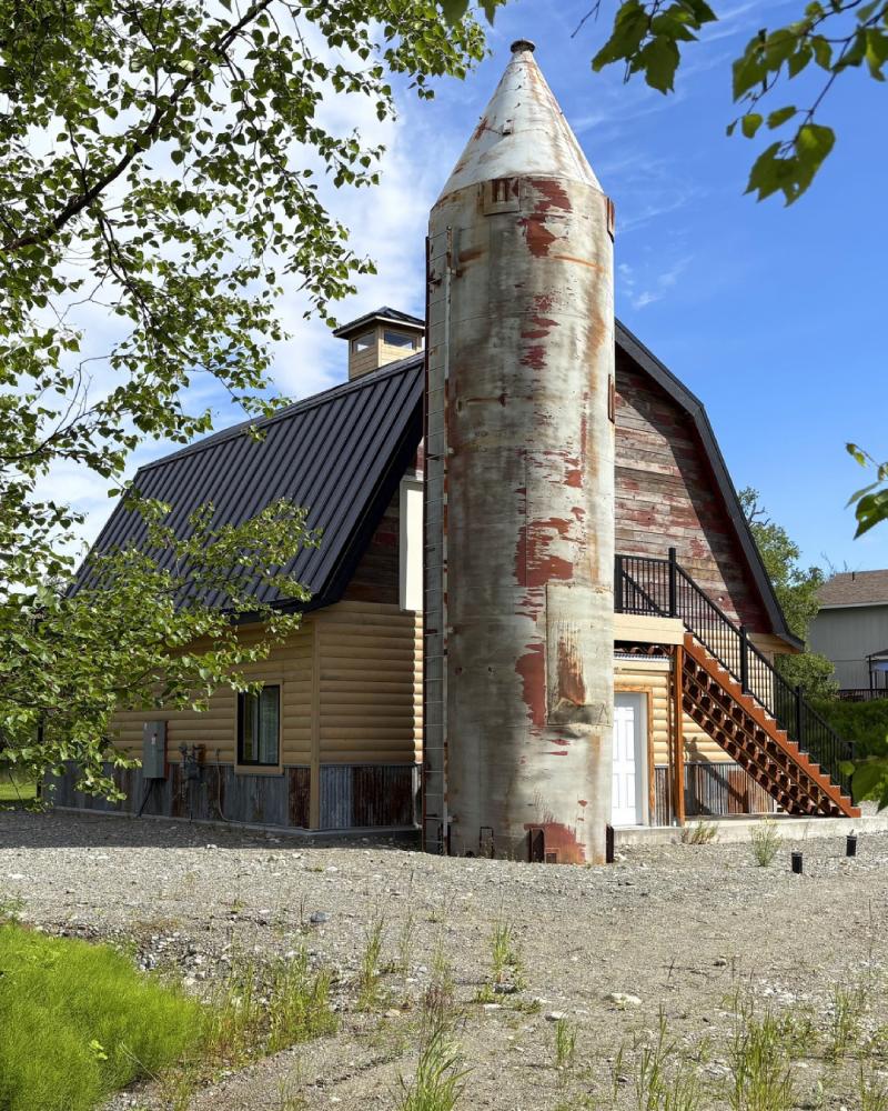 Exterior of Borealis Bison Barns featuring the restored barn, historic grain silo, wraparound deck, and surrounding Alaska landscape.